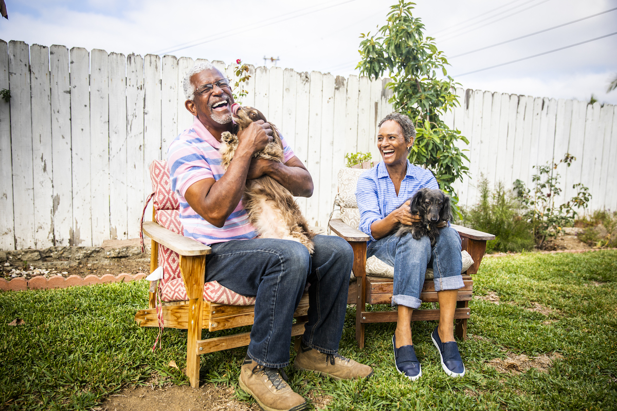 Senior couple playing with their dogs in the backyard