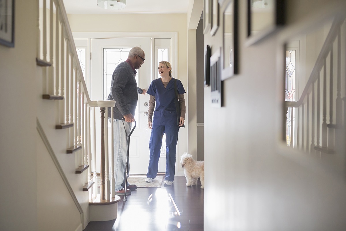 Home nurse checking on an older man at home