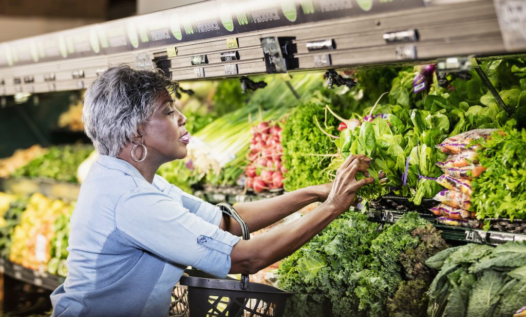 Senior woman shopping for salad greens for a story on foods to lower blood pressure