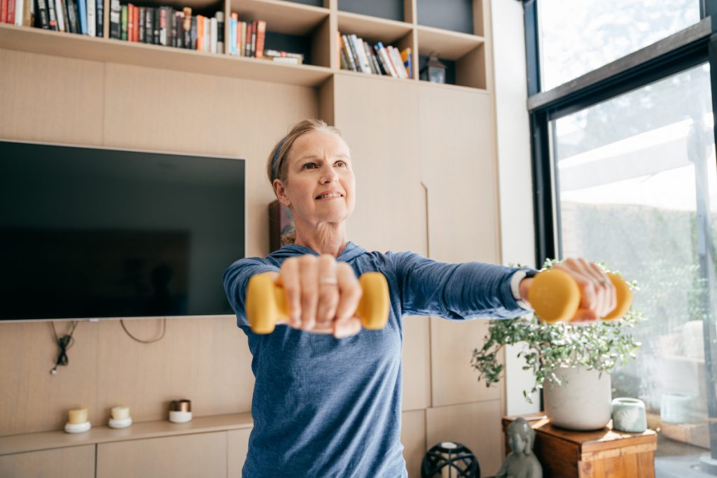 senior woman exercising at home for a story on exercising with osteoporosis