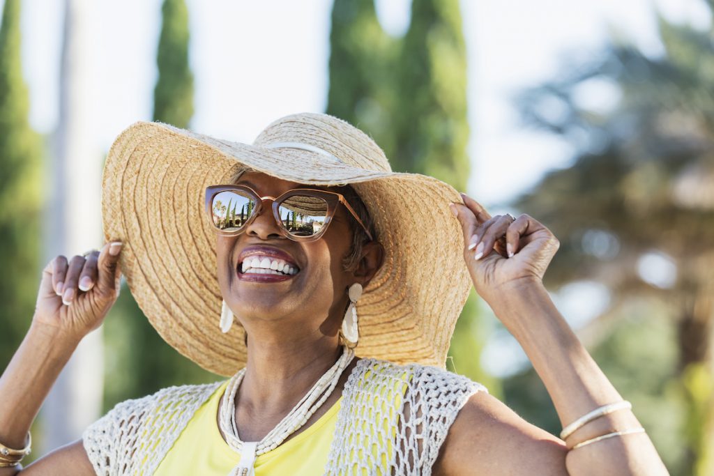 happy older woman enjoying the sunshine for s story on sun safety facts seniors should know about