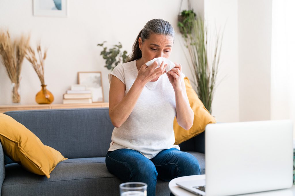 Older woman sneezing from allergies for a story on treating allergies after age 65