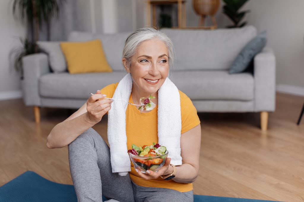 Happy senior woman eating after a workout for a story on anti-aging foods for older adults