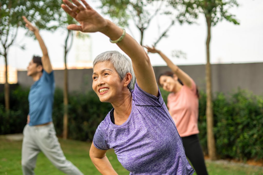 smiling senior woman exercising outdoors for a story on flexibility exercises for seniors