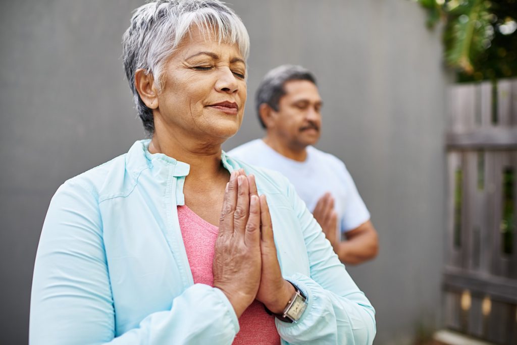 senior couple doing yoga together for a story on yoga poses to relieve headaches